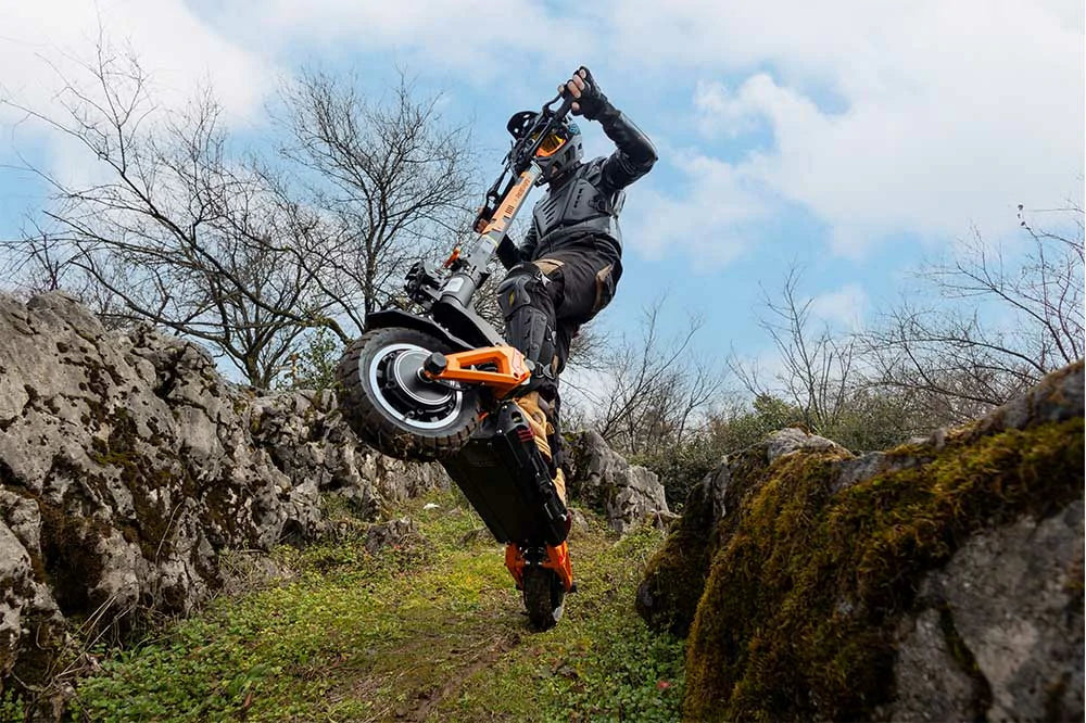 Kukirin G3 Pro electric scooter riding on grassy hill and dirt trail, off-road tires, dynamic motion.